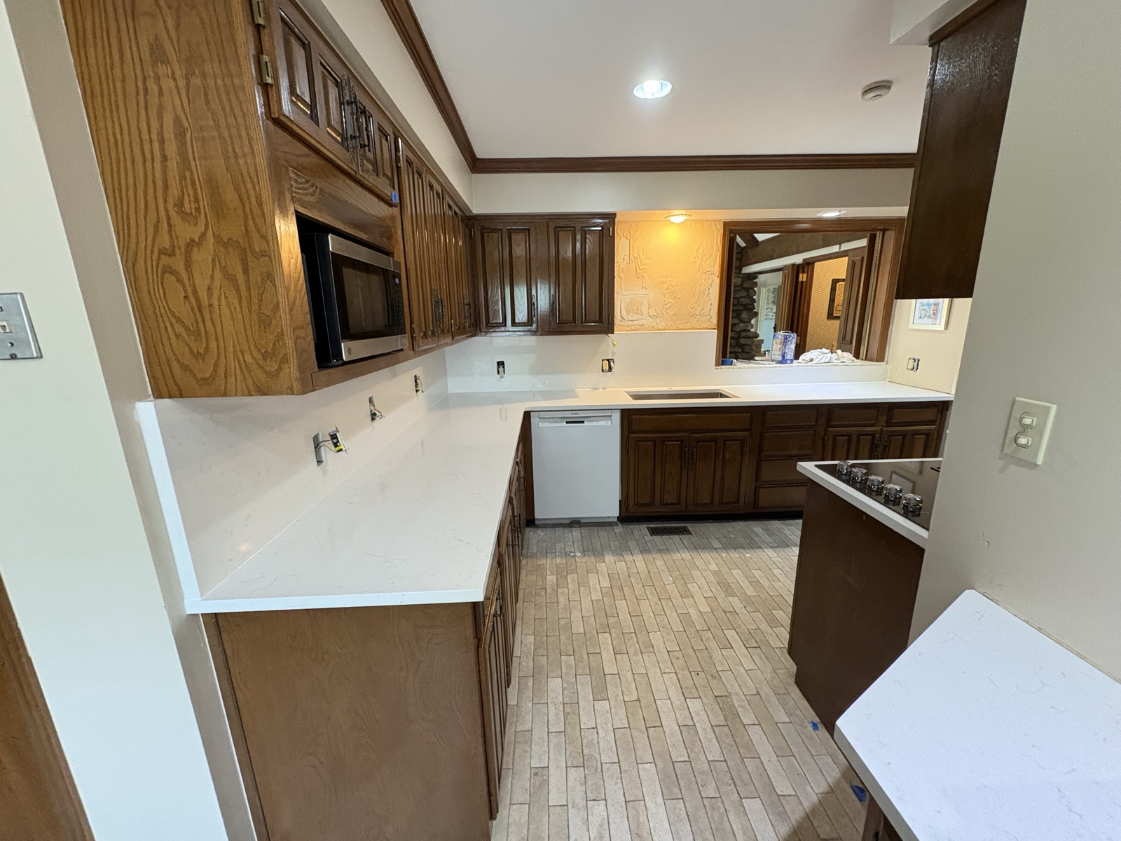 Marble-look quartz countertops in dark wood traditional kitchen